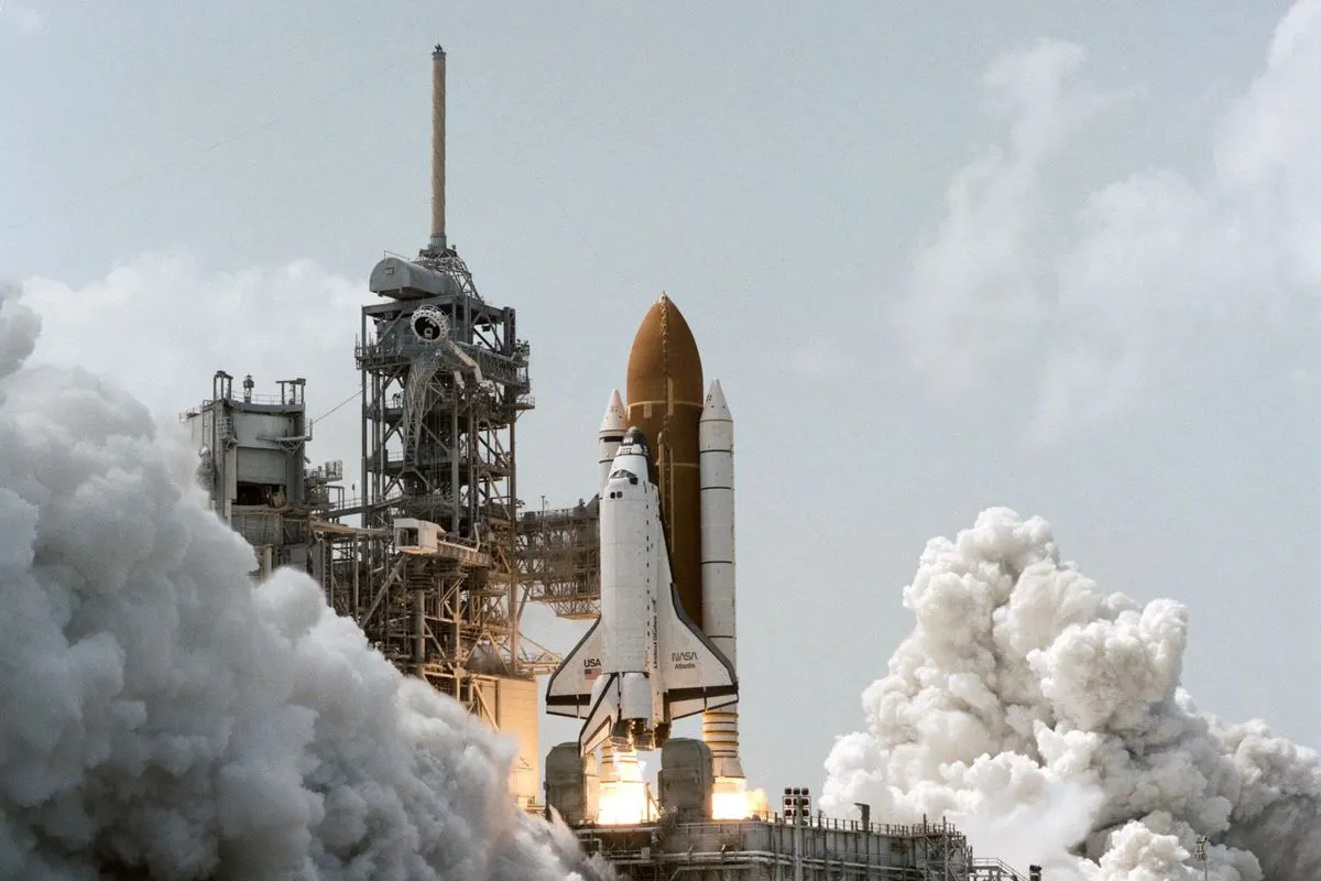 Space Shuttle Atlantis lifting off from a launch pad in a cloud of white smoke