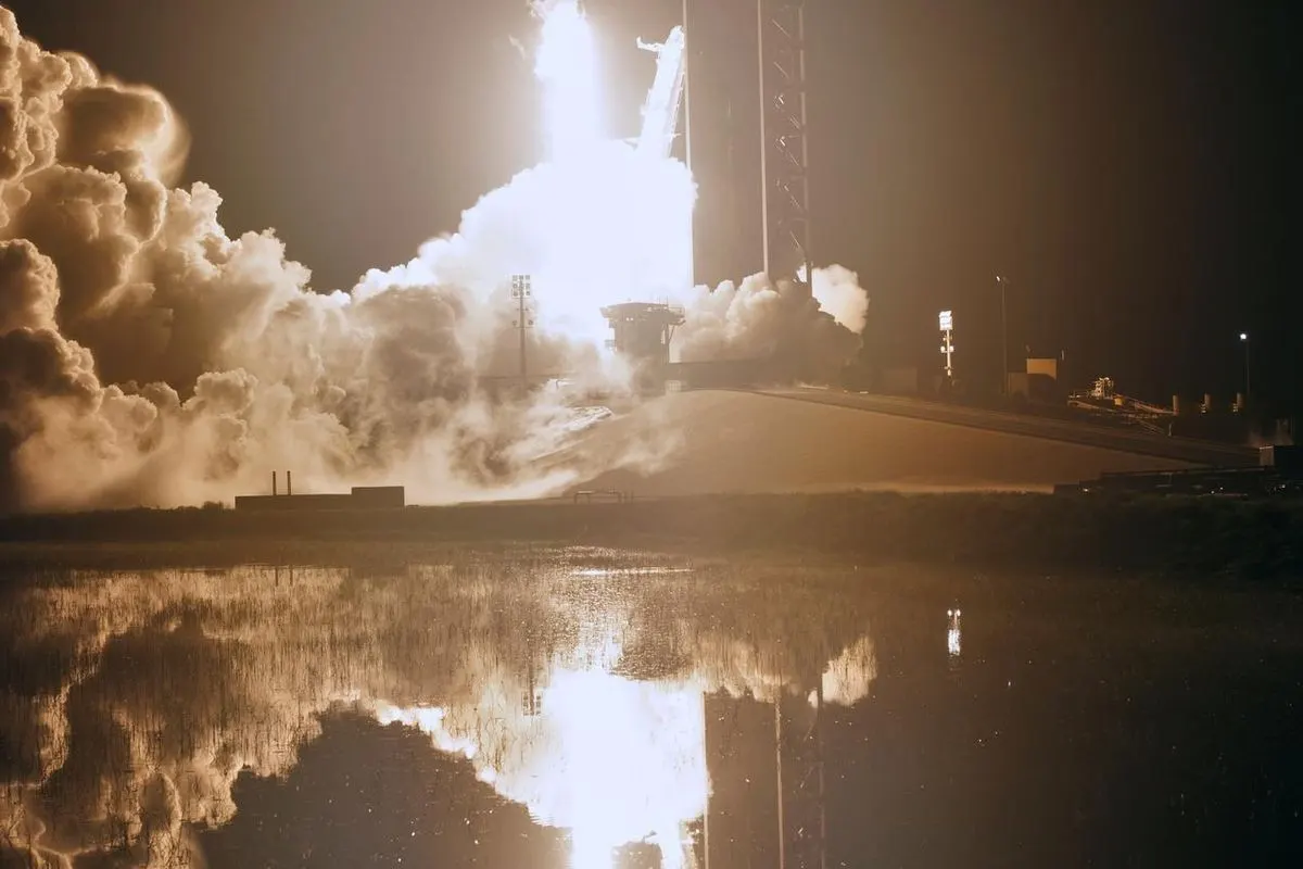 A Falcon 9 rocket lifting off from a launch pad at night with a bright glow